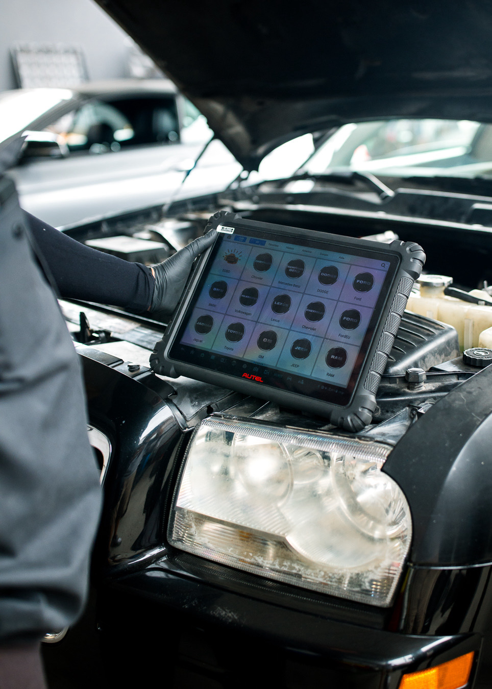 Technician running diagnostics with an Autel scan tool