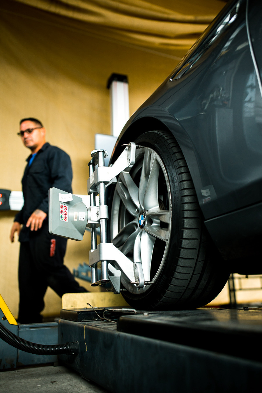 BMW on the alignment rack with sensor head mounted to the wheel