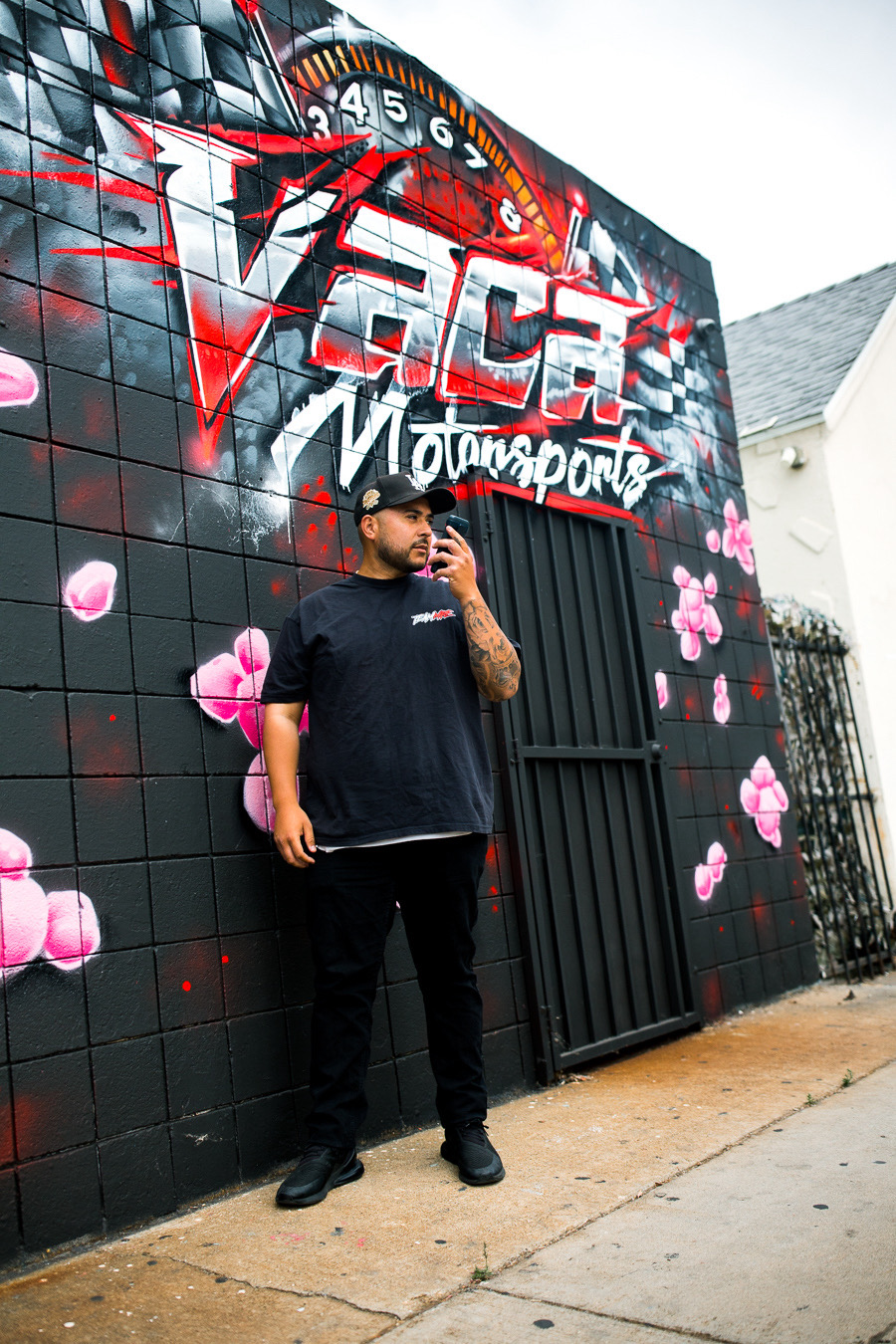 Owner standing in front of the Vaca Motorsports logo mural